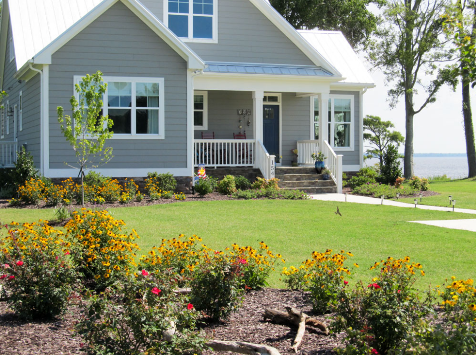 A house with flowers in the front yard.