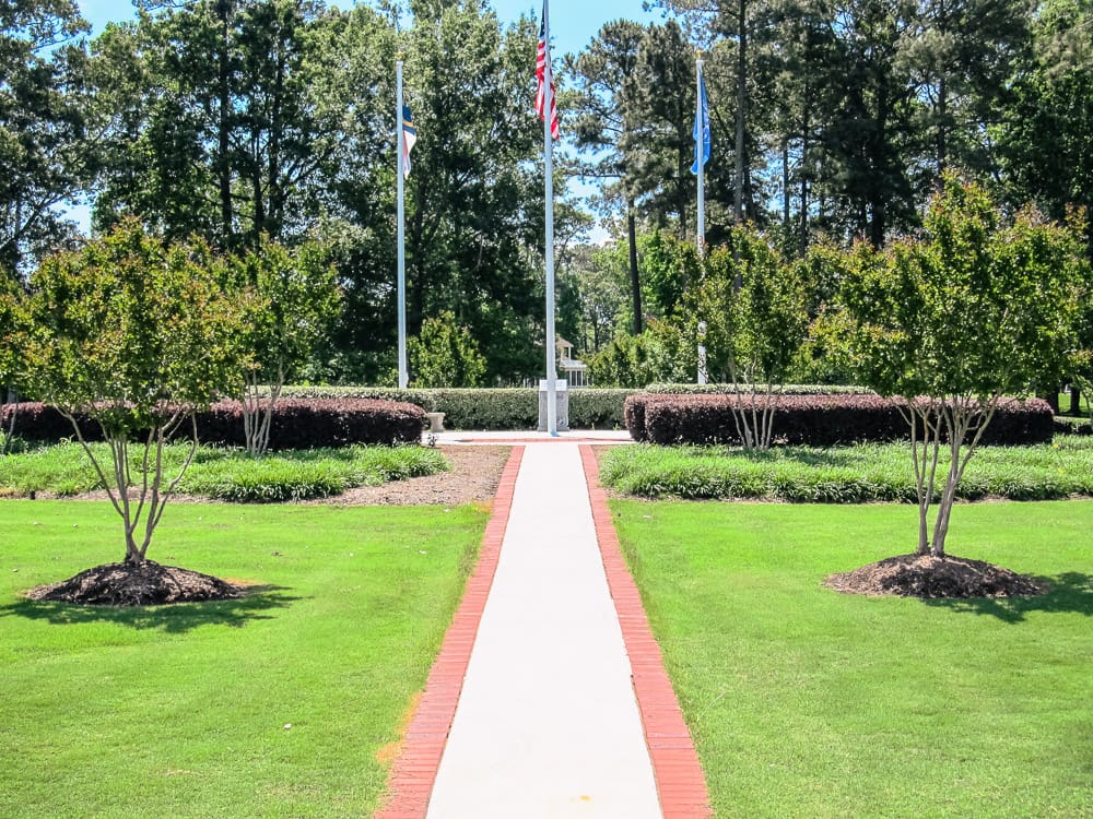 Long pathway and landscape garden trees and flag