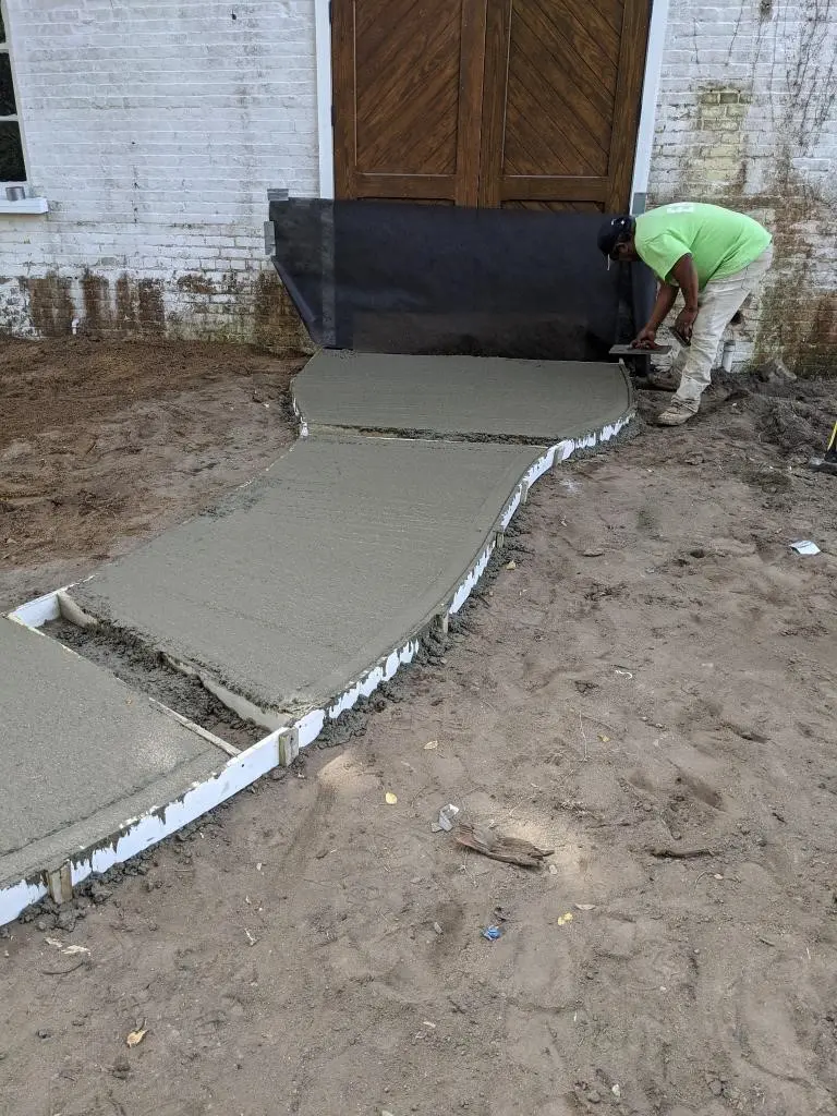 A man working on the ground in front of a house.