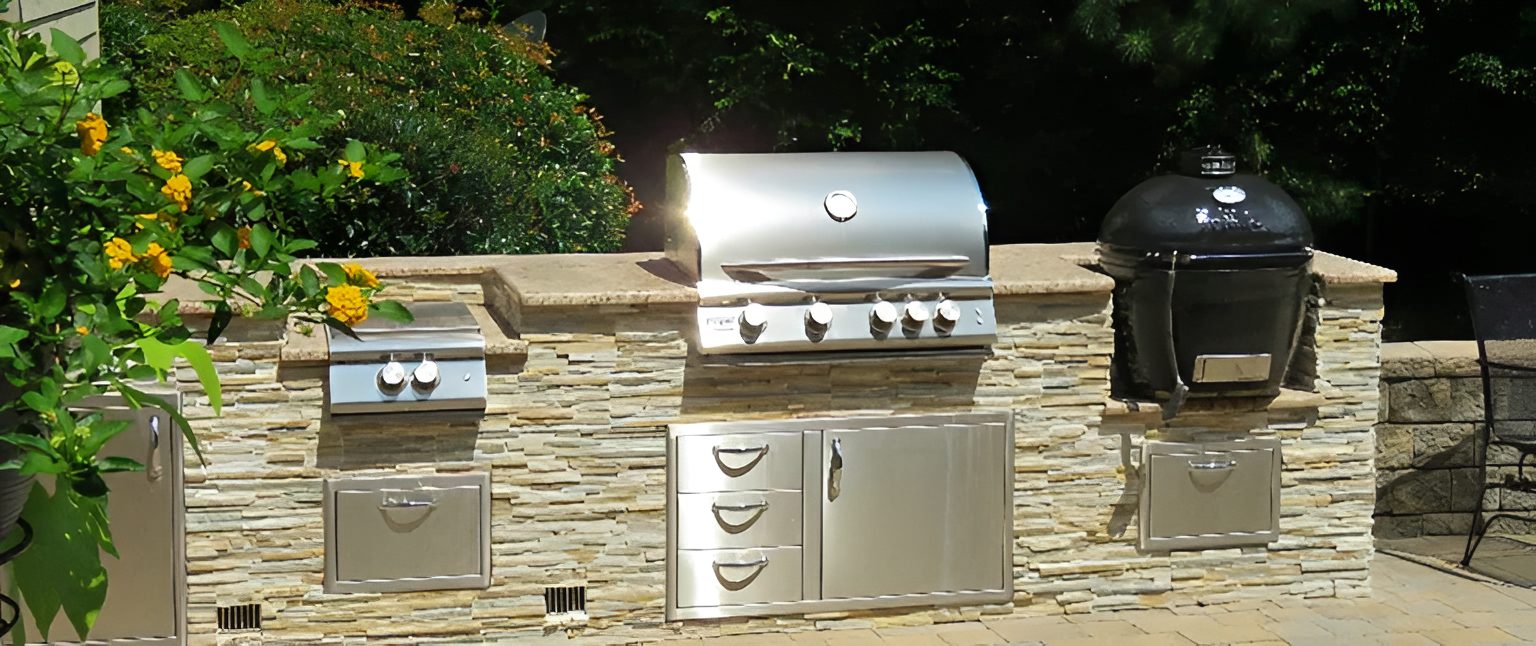 Outdoor kitchen with stainless steel grill appliances.