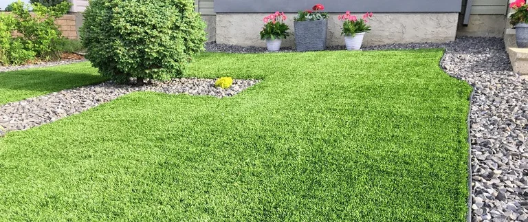 Well-maintained lawn with potted flowers and shrub.