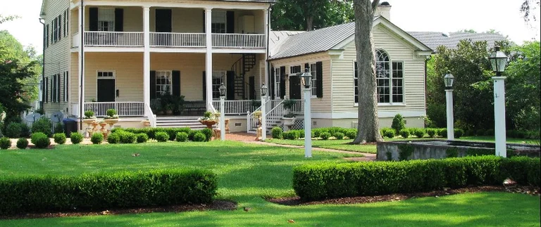 Two-story house with manicured green lawn.