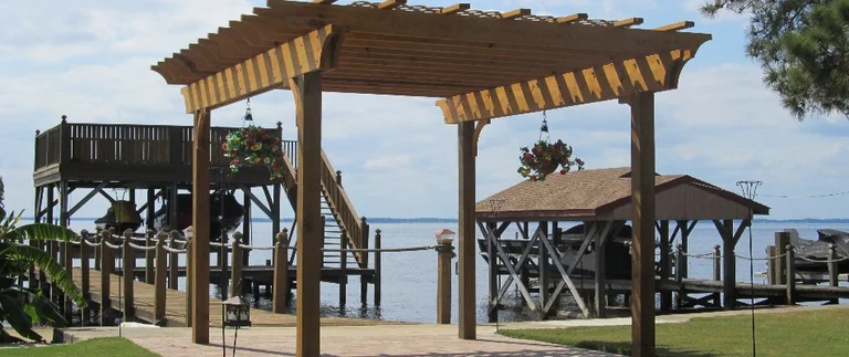 Wooden pergola and docks by the water.