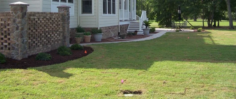 House exterior with grassy backyard and patio.