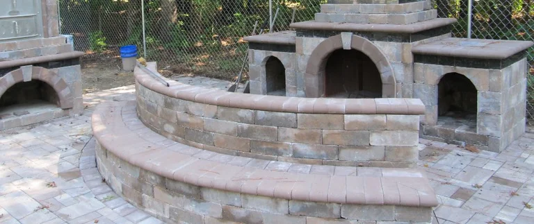 Stone outdoor fireplace with curved seating.