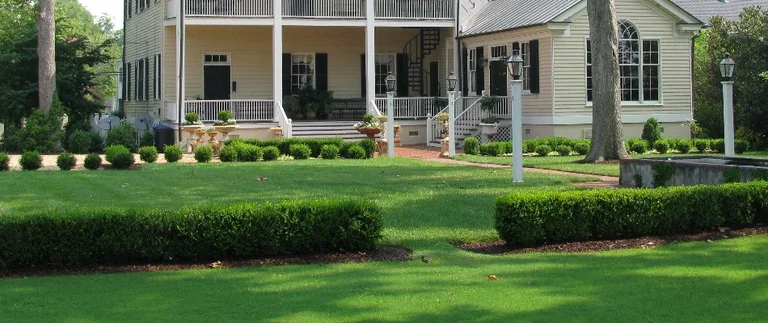 Large house with manicured lawn and garden.