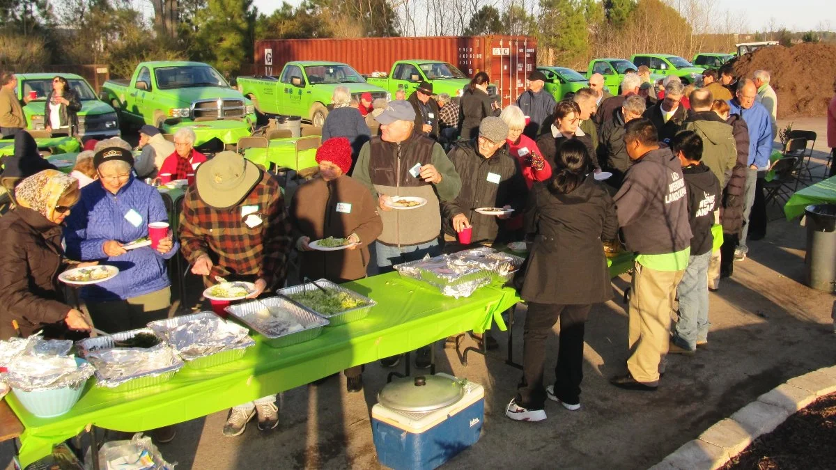 Community gathering with food tables outdoors.