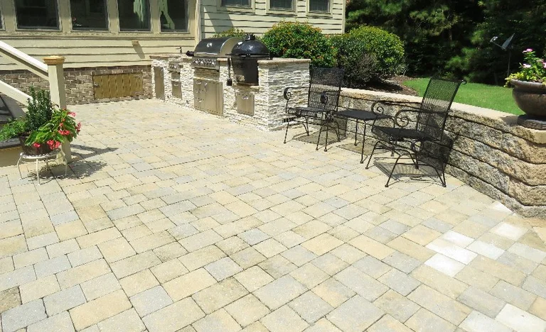 Stone patio with grill and seating area.
