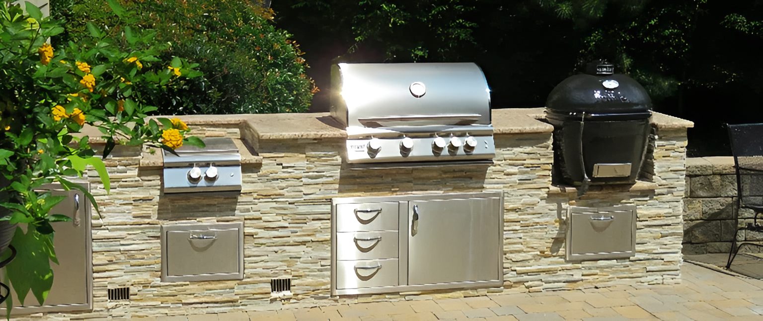 Outdoor kitchen with grills and storage cabinets.