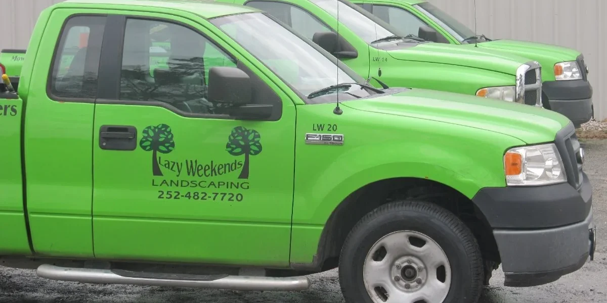 Green landscaping trucks parked in a row.